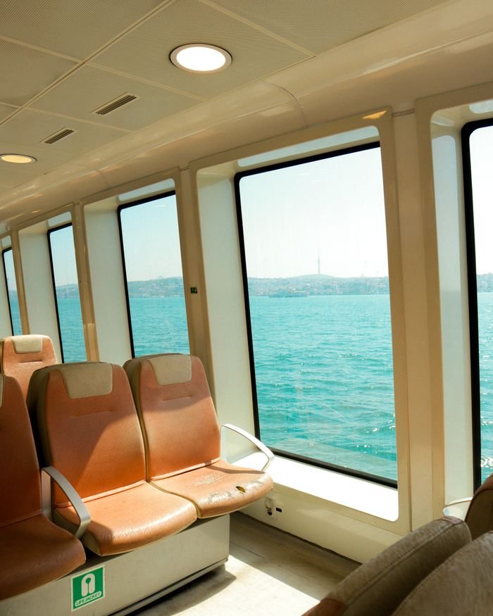 gallery-03 Interior of a ferry in Istanbul, showcasing the Bosphorus with spacious seating and large windows.